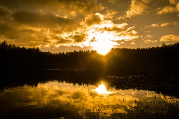 Paysage lacustre en automne, ciel couchant et rayons de soleil sur la forêt, silhouette de nature sauvage — Photo