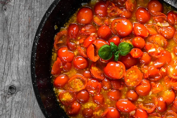 Wok con tomates fritos con albahaca y aceite de oliva para salsa de tomate, fondo de cocina, concepto de comida italiana — Foto de Stock