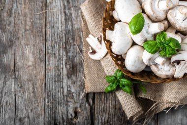 Ahşap masa, ek yükü bir sepet içinde taze champignon mantar