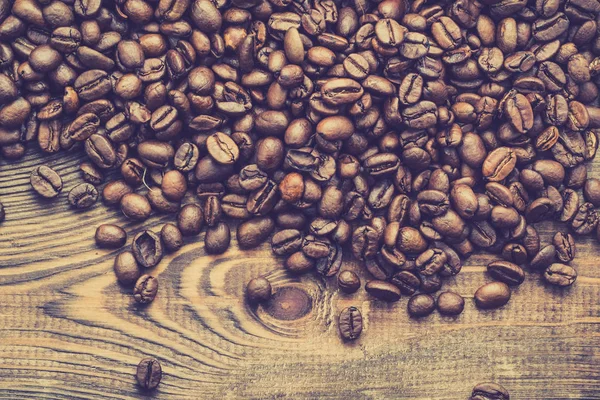 Фон из черных кофейных зерен, зерно кофе на деревянном столе, над головой — стоковое фото