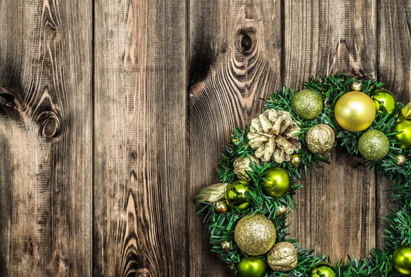 Пригода Різдвяний вінок на дерев'яному фоні, прикраса золотими прикрасами для повішення на двері — стокове фото