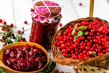 Kaşık ve kavanoz reçel ile kızılcık Beyaz ahşap zemin üzerinde 