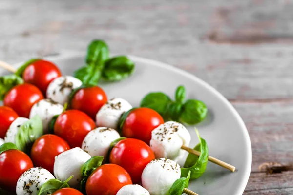 Caprese salatası - domatesli şiş, mozarella ve fesleğen, İtalyan yemeği ve sağlıklı vejetaryen diyet konsepti
