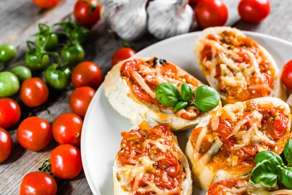 Tradiční italská jídla, předkrmy nebo bruschetta zapečená s rajčaty, bazalkou a sýrem — Stock fotografie