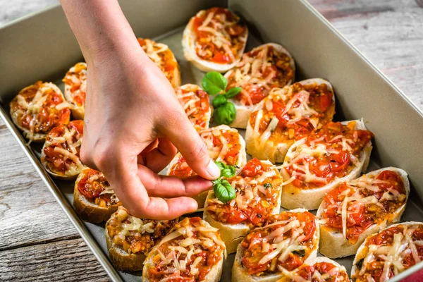 Şef yemek hazırlama İtalyan bruschetta domates, fesleğen ve peynir, gıda, ev yapımı meze parti için yemek süsleme