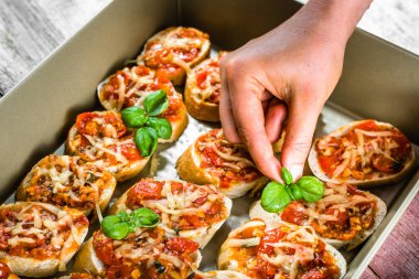 Şef Aşçı Restoran İtalyan gıda - parti için bruschetta pişmiş domates, fesleğen ve peynir, hazırlık antipasti ile süsleme