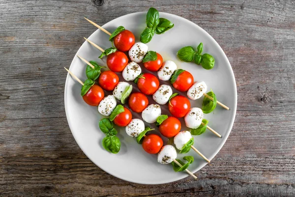 Caprese salatası - domatesli şiş, mozarella ve fesleğen, İtalyan yemeği ve sağlıklı vejetaryen diyet konsepti