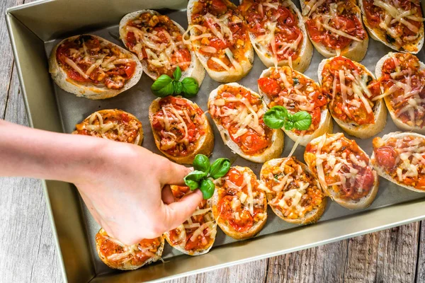 Şef hazırlık İtalyan yemeği Bruschetta Közlenmiş domates, fesleğen ve peynir, ev yapımı meze parti için yemek süsleme-