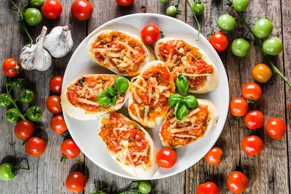 Italská bruschetta s rajčaty a bazalkou, pikantní předkrmy, pohled shora na desce pro strany nebo sdílení s přáteli — Stock fotografie