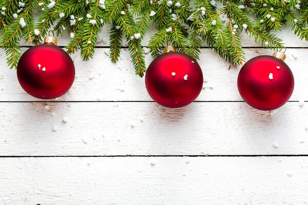 Festive christmas background with decoration - snowflakes on fir twigs and red balls on white wood