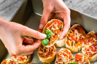 Şef restoran yemek İtalyan gıda - bruschetta pişmiş domates, fesleğen ve peynir, parti için hazırlık meze ile