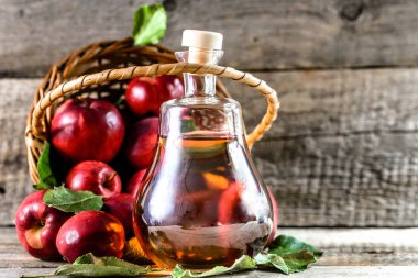 Şarap şişe ya da elma sirkesi, sağlıklı Detoks içecek ahşap arka plan üzerinde organik Kırmızı elma ile