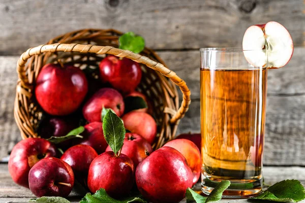 Смачний яблучний сік у чашці та червоні яблука на дерев'яному столі, органічна їжа та концепція здорового способу життя — стокове фото