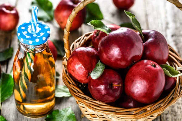 Frischer Apfelsaft in der Flasche - Entgiftungsgetränk mit roten Äpfeln auf Holztisch, Bio-Lebensmittel und gesundes Lifestylekonzept — Stockfoto