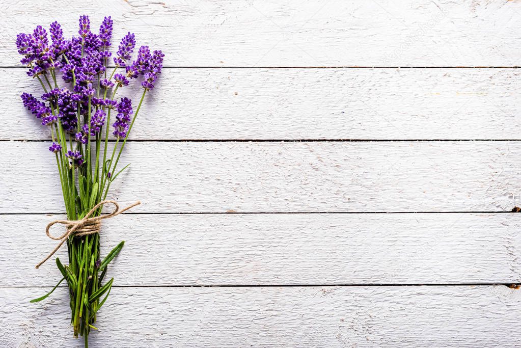 Fresh flowers of lavender bouquet, top view on white wooden background