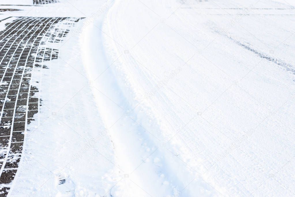 Background with snow on road in winter and footpath paving, text