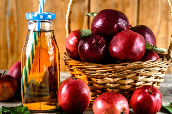 Свіжий яблучний сік у пляшці - пийте з червоними яблуками на столі, органічною їжею та концепцією здорового способу життя — стокове фото