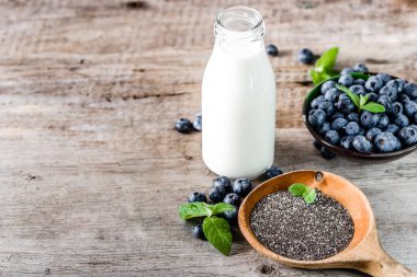 Taze süt şişesi, çilek ve tohum madde chia puding, sağlıklı gıda superfood kahvaltı hazırlığı