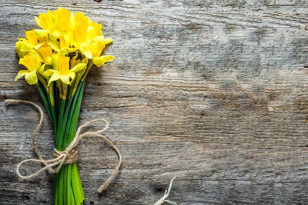 Fondo de primavera, narcisos de Pascua, ramo en mesa de madera — Foto de Stock