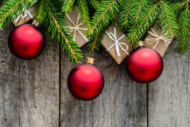 Noel hediye kutuları ve süs eşyaları - çam dalları üzerinde ahşap masa, üstten görünüm üzerinde kırmızı baubles ile arka plan