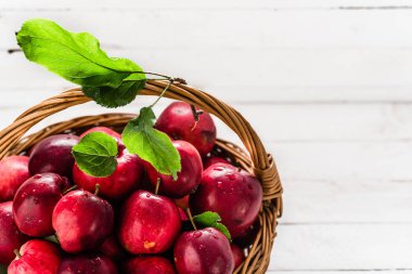 Sepette beyaz zemin üzerine taze elma meyve yığını masada kırmızı elmalar