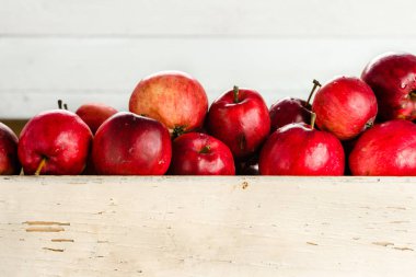 Ahşap sandık, beyaz zemin üzerine taze elma yığını tablo kırmızı elmalar