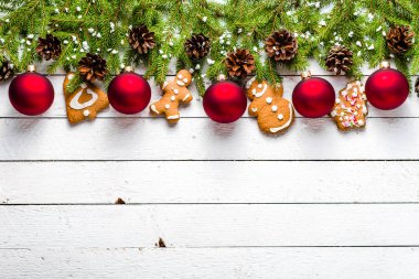 Noel süslemeleri, kırmızı süsler ve gingerbread çerezleri ve köknar ağacı Beyaz ahşap masa üzerinde arka plan