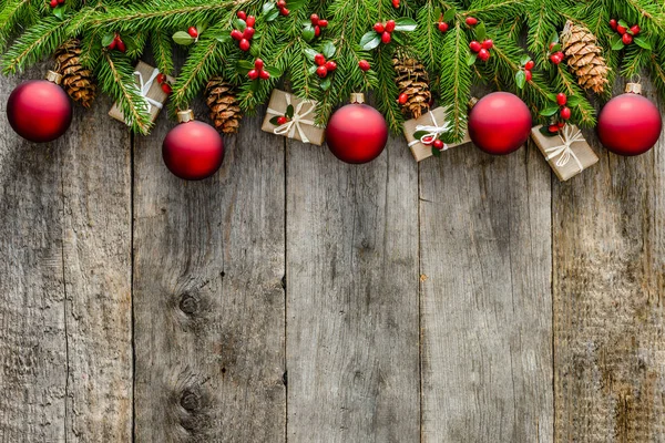 Çam dalları dekorasyon - hediye kutuları, çam kozalakları, holly ve kırmızı ornements. Noel arka plan, üstten görünüm, kopya alanı.