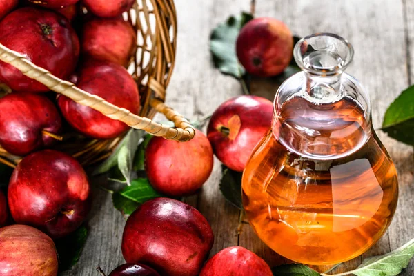 Винна пляшка або яблучний оцет, здоровий детоксикаційний напій з органічними червоними яблуками на столі — стокове фото