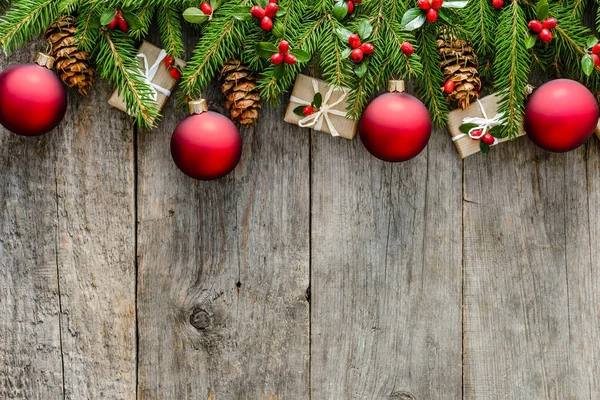 Rami di abete con ornamenti - scatole di regalo, pigne agrifoglio e bagattelle rosse. sfondo di Natale, spazio di copia — Foto Stock