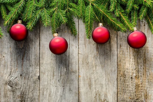 Boże Narodzenie tło z gałęzi jodły i ozdoby - czerwone bombki na desce, widok z góry — Zdjęcie stockowe