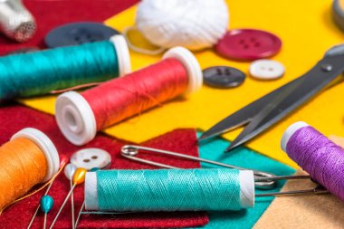 Renkli keçe üzerinde çeşitli dikiş aksesuarları.