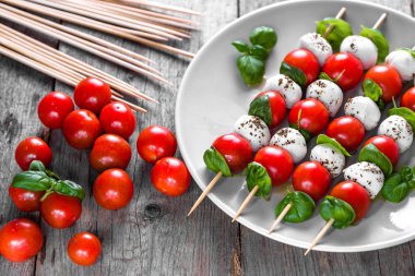 Caprese salatası - domatesli şiş, mozarella ve fesleğen, İtalyan yemeği ve sağlıklı vejetaryen diyet konsepti