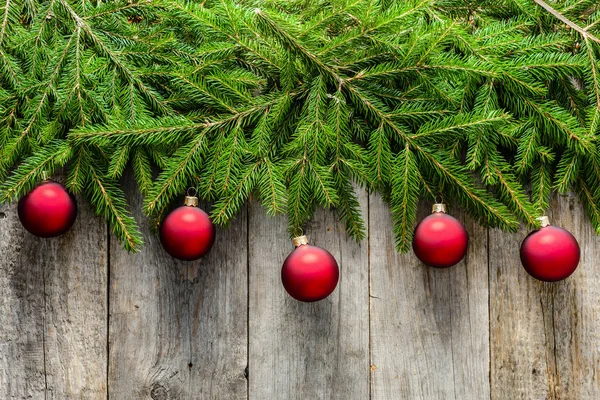 Sfondo natalizio con ornamenti su rami di abete, decorazione natalizia su tavole di legno, vista dall'alto — Foto Stock