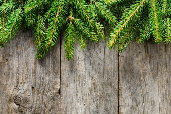 Vánoční pozadí s větvemi jedlí na dřevěný stůl, pohled shora — Stock fotografie