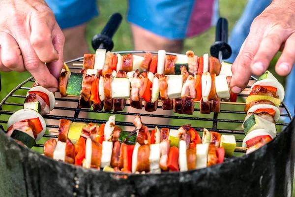 Grilling shashlik on barbecue grill, chef cook putting on bbq skewers with meat and vegetables, roasted food, outdoor cooking for party in the garden — Stock Photo, Image