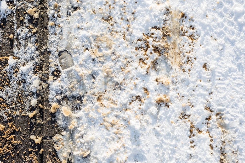 Melting snow on pavement in winter, texture