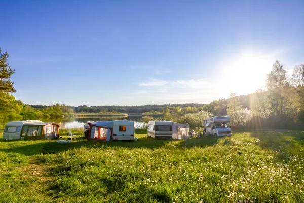 Karavanlar ve gölde kamp. Aile tatil açık havada, trav