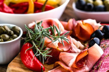 Geleneksel İspanyol tapa jamon serrano veya İtalyan meze prosciutto, ham ham ahşap tahta üzerinde dilimlenmiş