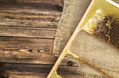 Jüt tutuyordu, üstten görünüm ile peteğin rustik ahşap zemin üzerine bal ile kaplı.