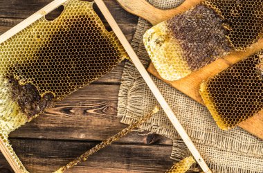 Jüt tutuyordu, üstten görünüm ile peteğin rustik ahşap zemin üzerine bal ile kaplı.