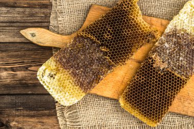 Jüt tutuyordu, üstten görünüm ile peteğin rustik ahşap zemin üzerine bal ile kaplı.