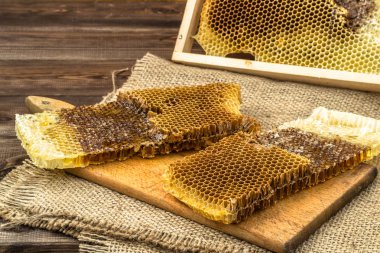 Jüt tutuyordu, seçici odak ile peteğin rustik ahşap zemin üzerine bal ile kaplı.