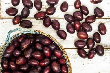 Ahşap arka plan üzerinde sepet içinde taze Erik Erik.