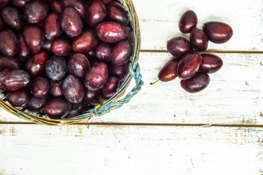 Ahşap arka plan üzerinde sepet içinde taze Erik Erik.