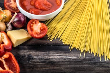 Ahşap masa üzerinde düzenlenmiş spagetti bolognese maddeler.