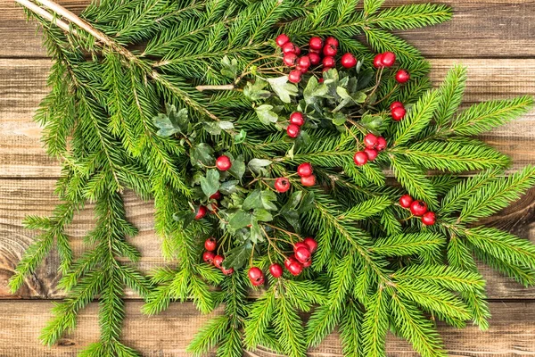 Weihnachtlicher Hintergrund mit Ornamenten auf Tannenzweigen, Feiertagsdekoration auf Holzbrettern, Draufsicht — Stockfoto
