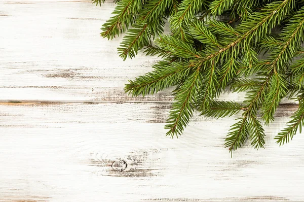 Rama de árbol de Navidad verde sobre fondo de madera — Foto de Stock