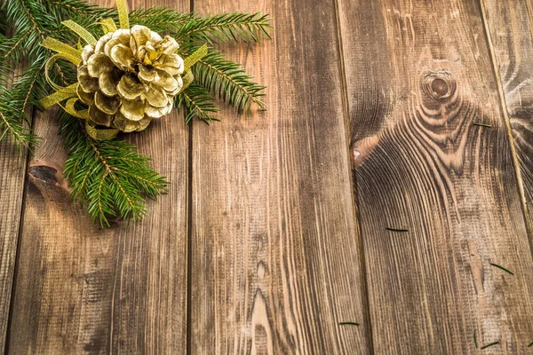 Ξύλινο υπόβαθρο με Χριστουγεννιάτικη διακόσμηση, Κουκουνάρα που κρέμεται σε υποκατάστημα της χριστουγεννιάτικο δέντρο — Φωτογραφία Αρχείου