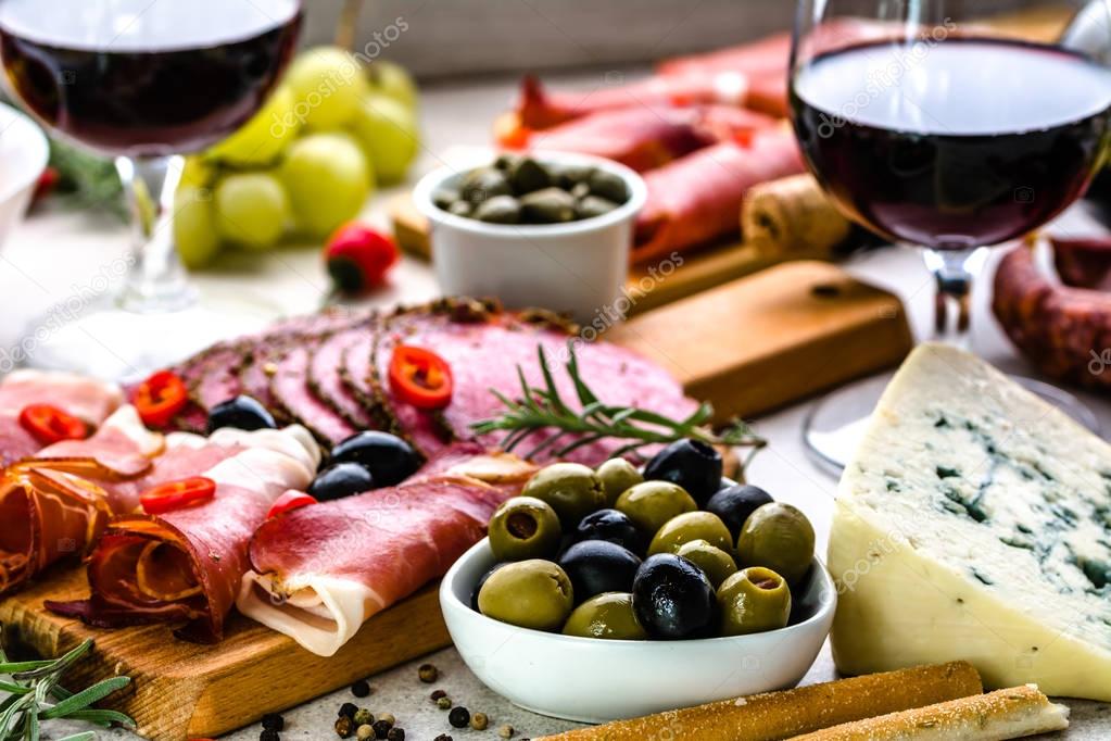 Variety food on table, wine snack set, olives, cheese and other appetizer, italian antipasti on plate